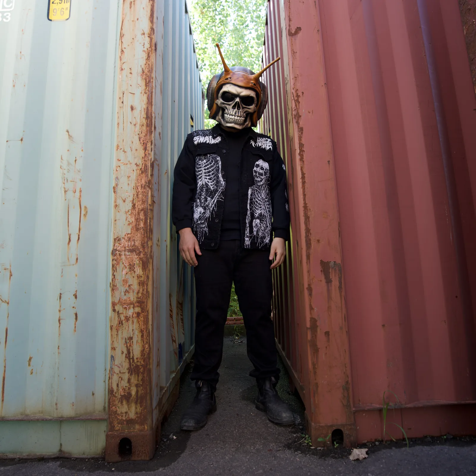 SLUGZ skull character between weathered shipping containers